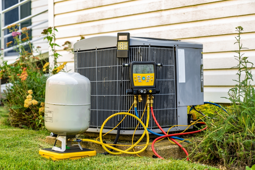 Outdoor air conditioning unit connected to service gauges and hoses