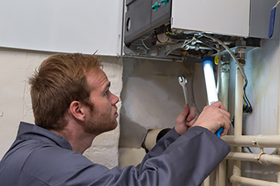 Technician working on a wall-mounted heating unit